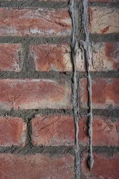 Brickwork made of hand-molded red brick and hand-mixed cement mortar. Stock Photos