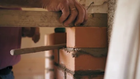 Brickwork process. A constructional worker is levelling and is knocking a brick Stock Footage 90089102
