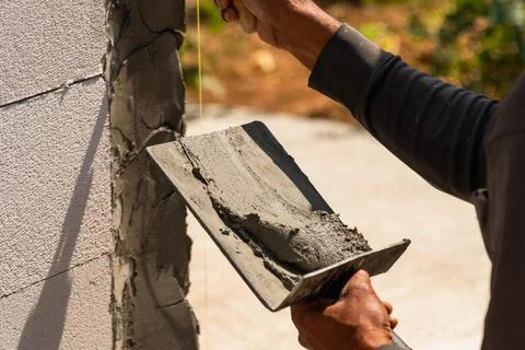Brickwork troweling process at construction site close-up action scene in b.. Stock Photos