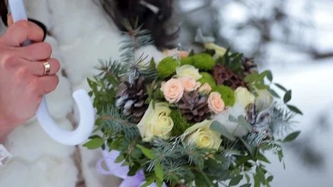 Bridal bouquet in hands in the winter. White Umbrella. Stock Footage 106926890