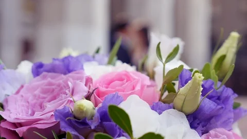 Bridal bouquet sharp in foreground with bride and groom in soft focus background Vidéo 118774153