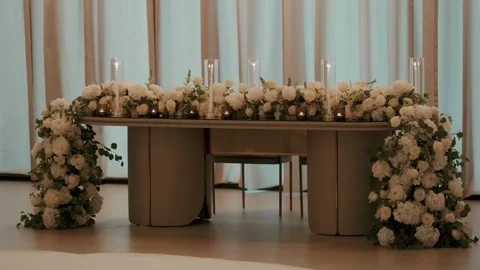 Bridal Head Table With White Rose Installation and Hurricane Candles Stock Footage 344013534