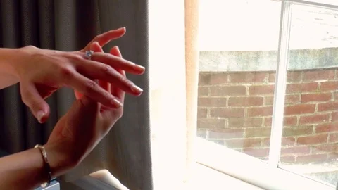 Bride adjusting ring in front of a window Stock Footage 95497082