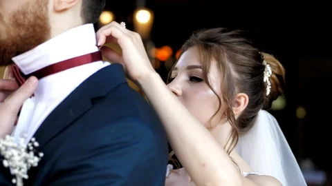 Bride adjusts bow tie on groom preparing for wedding event Stock Footage 119628347
