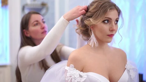 The bride adjusts the makeup near the mirror in a gorgeous room Stock Footage 102433428