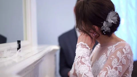 The bride adjusts the makeup near the mirror in a gorgeous room 库存影片 102433744