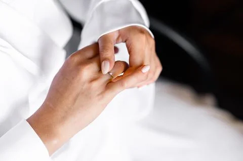 The bride adjusts the wedding ring on her finger Stock Photos