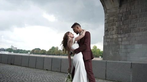 A bride and groom are dancing in front of a bridge Vidéo 267875368