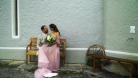 The bride and groom are sitting on a bench and kissing. wedding event. blur Stock Footage 279719987