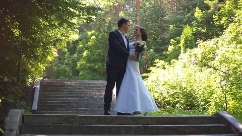 The Bride and Groom are Walking Along the Park Alley Stock Footage