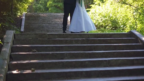 The Bride and Groom are Walking Along the Park Alley Stock Footage