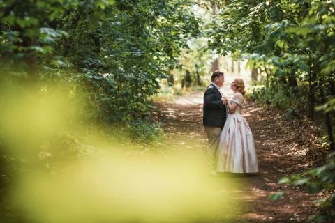 Bride and groom dancing in the forest background and sunlight Stock Photos