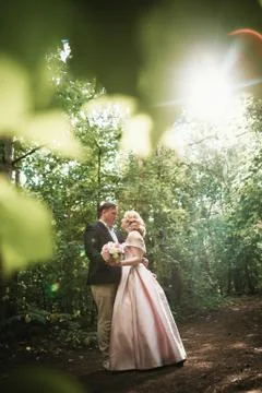 Bride and groom dancing in the forest background and sunlight Stock Photos