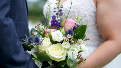 A bride and groom facing each other, holding a bouquet. Stock Footage 288713259