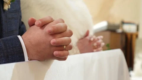 The bride and groom folded their arms in prayer during the church wedding. Stock Footage 165678333