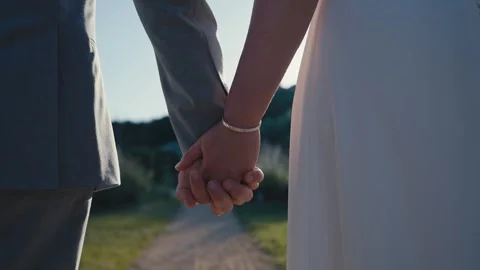 Bride and Groom Holding Hands on Garden Path at Sunset Stock Footage 340549487