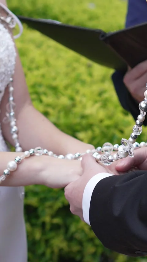 Bride and groom holding hands while getting married in an outdoor religious Stock Footage 344985058