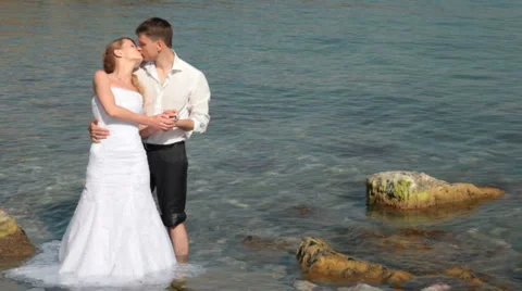 Bride and groom kissing near the sea Stock Footage