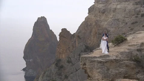 Bride and groom posing on the edge of the cliff background of the sea Stock Footage 94214695