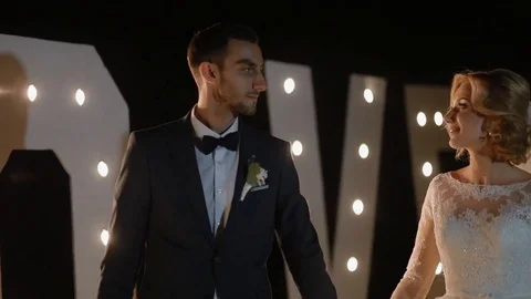 Bride and groom posing in front of the lights Stock Footage 73518269