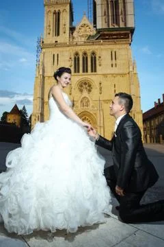 Bride and groom posing in front of cathedral Stock Photos