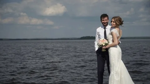 The bride and groom posing on the pier for the photographer Stock Footage 70161687