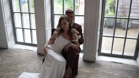 Bride and groom posing by window in elegant hardwoodfloored event venue Vidéo 267877649