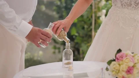 Bride and groom pouring sand from two Stock Video Pond5