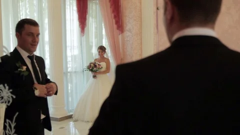 Bride and groom reflected in the mirror. Loving couple looking at each other. Stock Footage 74714403