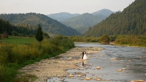 Bride and groom, the river on the mountain in the Carpathians Stock Footage 101678142