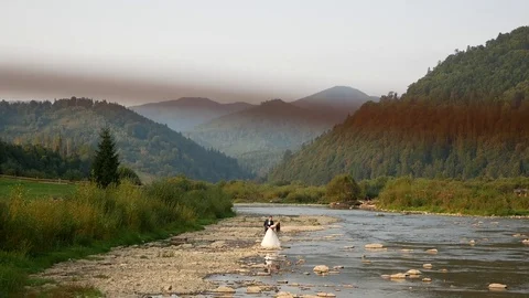 Bride and groom, the river on the mountain in the Carpathians Stock Footage 101678162
