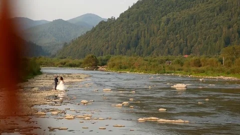 Bride and groom, the river on the mountain in the Carpathians Stock Footage 101678182