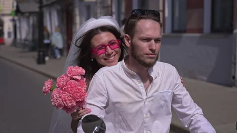 The bride and groom rode through the streets on their pink moped Stock Footage 239766285