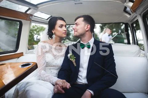 Bride and groom sitting in the car Stock Photos