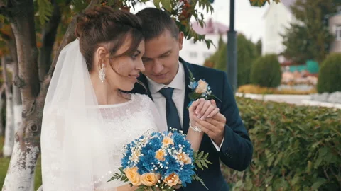 The bride and groom stand hugging under a tree in autumn, close-up Stock Footage 139621998