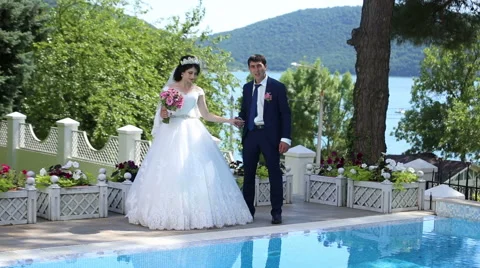 The bride and groom standing by the pool Stock Footage 68905339