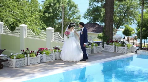 The bride and groom standing by the pool Stock Footage 68905398