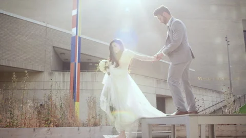 Bride and groom step down from table in beautiful outdoor setting Stock Footage 310155860