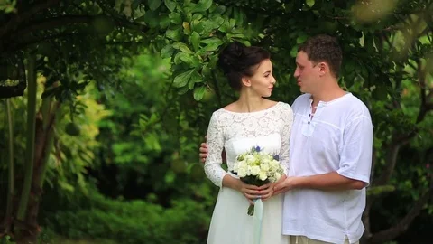 The bride and groom surrounded by palm trees looking into the distance Stock Footage 76180305