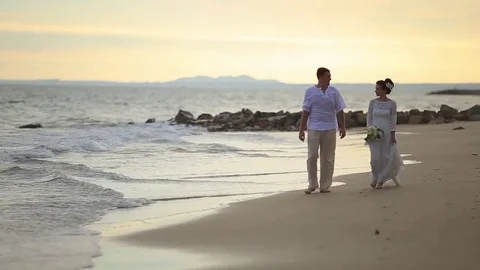 The bride and groom surrounded by palm trees looking into the distance Stock Footage 76180424