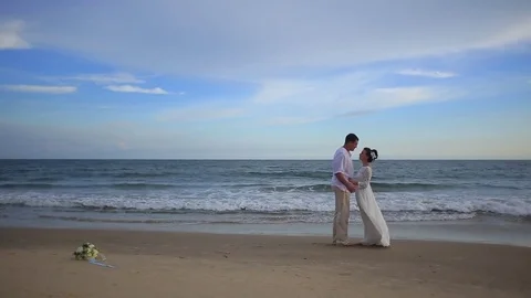The bride and groom surrounded by palm trees looking into the distance Stock Footage 76180502