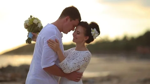 The bride and groom surrounded by palm trees looking into the distance Stock Footage 76180591