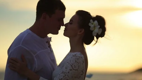 The bride and groom surrounded by palm trees looking into the distance Stock Footage 76180647