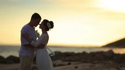 The bride and groom surrounded by palm trees looking into the distance Stock Footage 76180664