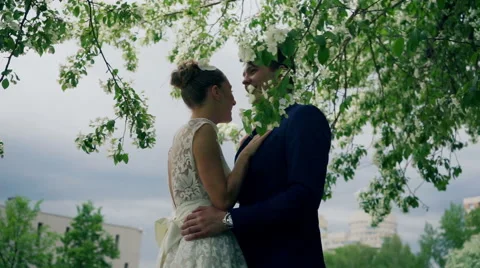 Bride and groom under the apple tree Stock Footage 61783475