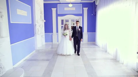 The bride and groom walk down the hall Stock Footage 68542950