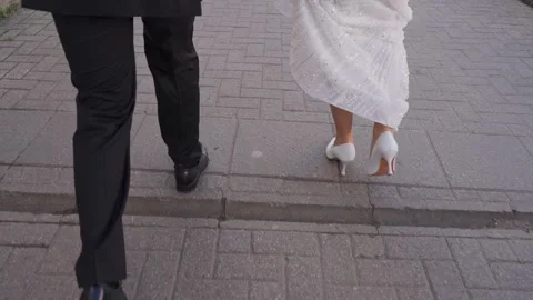 The bride and groom walk down the street arm in arm Stock Footage 329249269