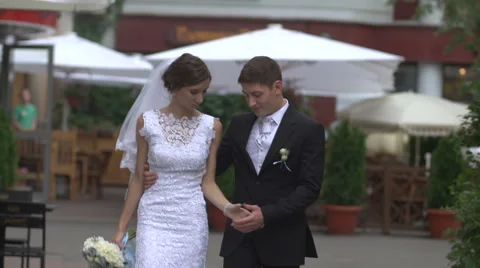 Bride and groom walking down the street, holding hands Stock Footage 61855337