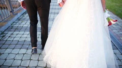 Bride and groom walking down the street holding hands Stock Footage 66875616