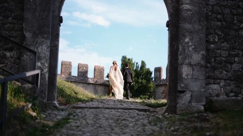 Bride and groom walking into the old castle. Stock Footage 100234783